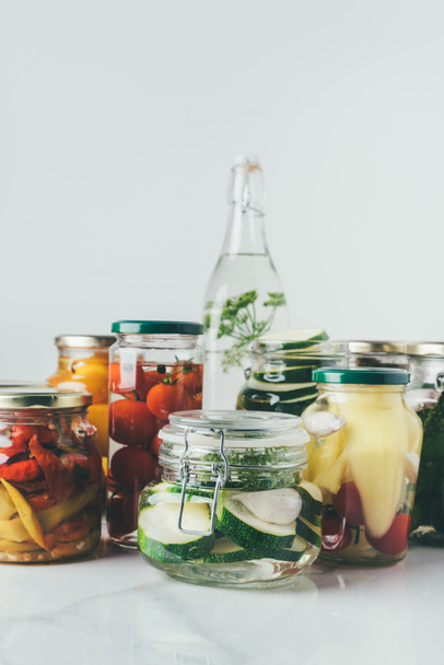 Gläser mit eingelegtem Gemüse auf dem Tisch in der Küche - Foto, Bild
