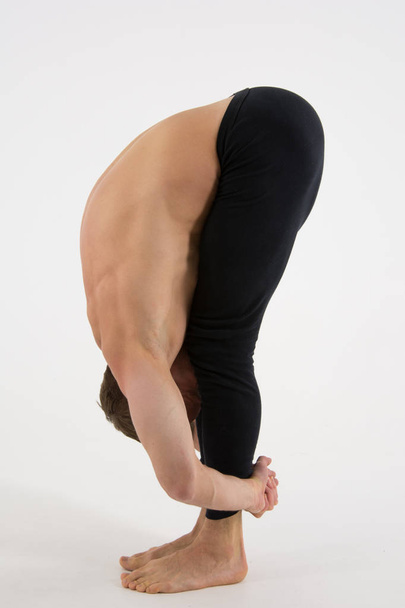 Young handsome man and exercises. Training and relaxation. Healthy lifestyle. Splits - Photo, Image