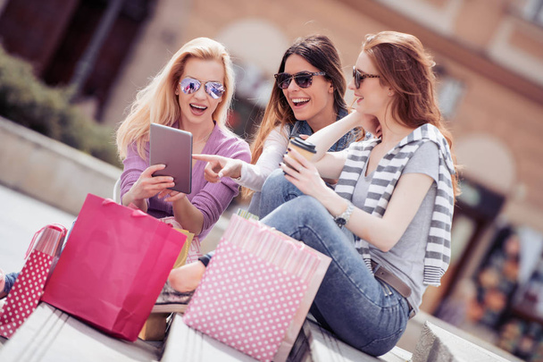 Três belas jovens mulheres com sacos de compras na cidade
. - Foto, Imagem