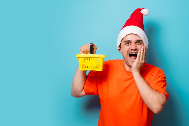 hombre con sombrero de Navidad y cesta de supermercado
 - Foto, imagen