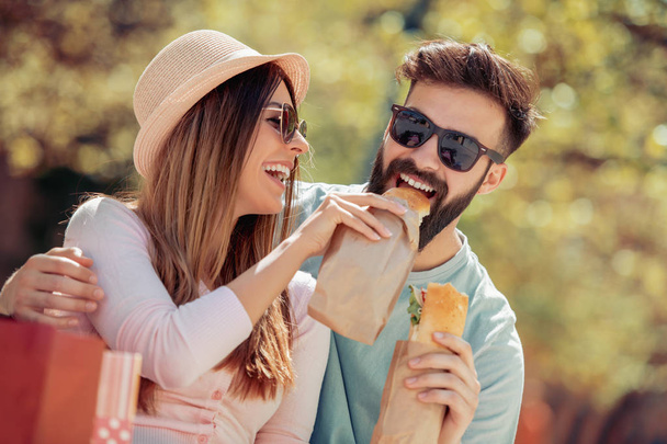 Couple manger un sandwich à l'extérieur, avoir du bon temps ensemble
. - Photo, image