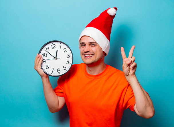 hombre con sombrero de Navidad y reloj grande
 - Foto, imagen