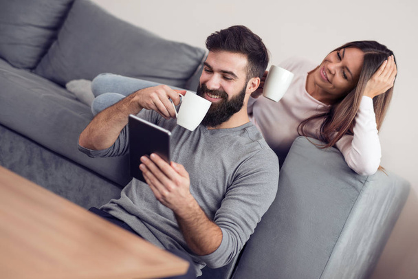 Feliz joven pareja disfrutando de tiempo en línea en la tableta
. - Foto, imagen