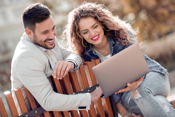 Beautiful romantic couple having rest in the city with laptop.  - Photo, Image