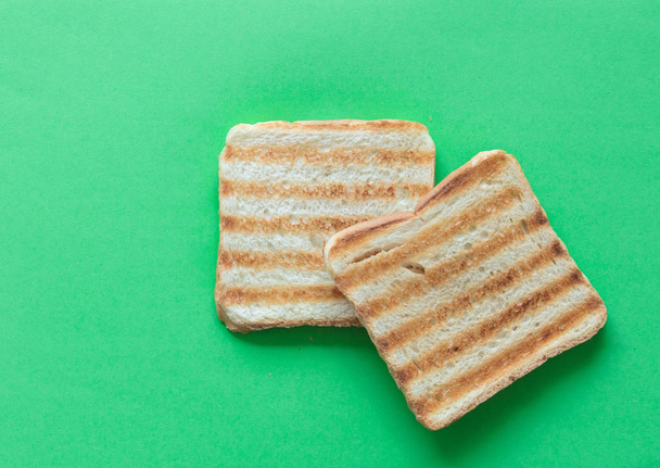 Φέτες ψωμί του τοστ σε πράσινο φόντο - Φωτογραφία, εικόνα