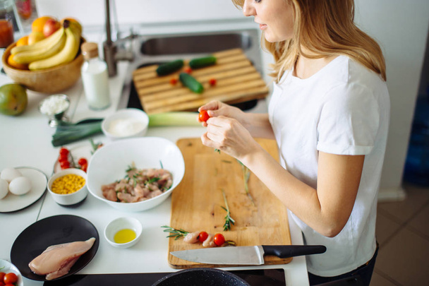 Woman making kebabs from meat and vegetable on chopping board in kitchen - Foto, Imagem
