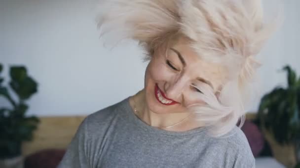 A woman of natural beauty with white hair and red lipstick laughs and waved her head to the left and to the right, her hair beautifully flies in different directions. - Footage, Video