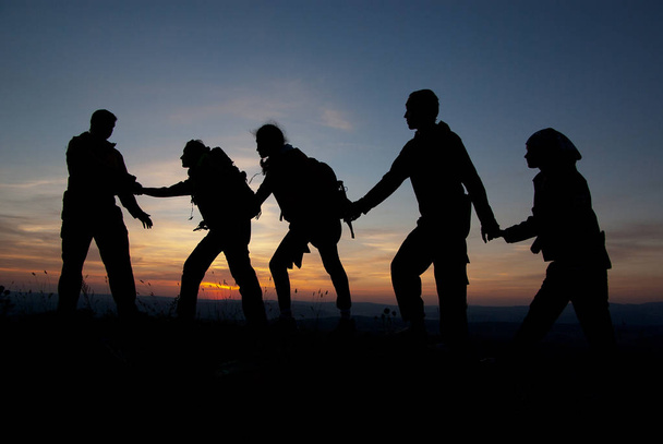 Egy csoport a turisták a naplemente egy hegy tetején. - Fotó, kép