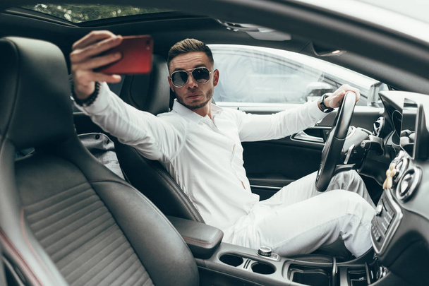 Knappe jonge Man zit in het luxe voertuig - Foto, afbeelding