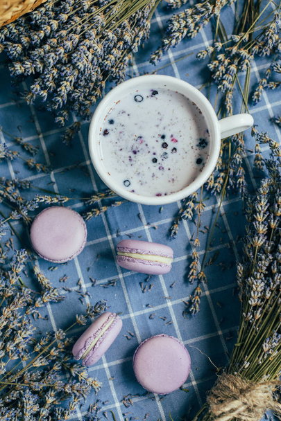 Bovenaanzicht van gekruide melk met lavendel op blauwe achtergrond met lavendel - Foto, afbeelding