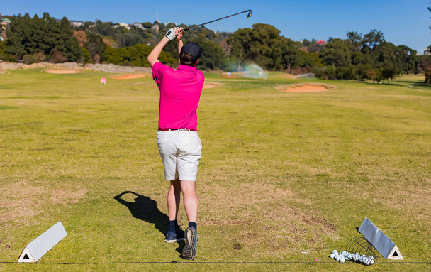 Man teeing off on a golf course Driving Range with a driver - Foto, Imagen