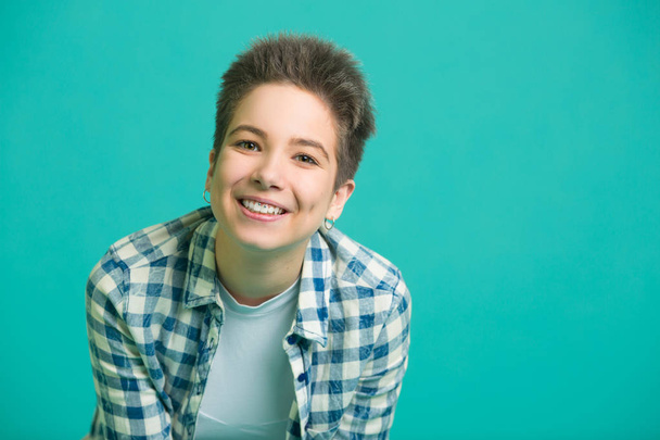 beautiful young girl with short hair in a shirt on a blue background - Foto, immagini