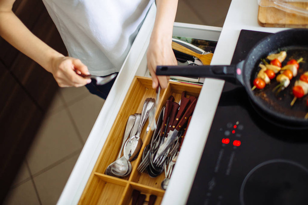 Young woman cleans dishware in kitchen - Fotó, kép