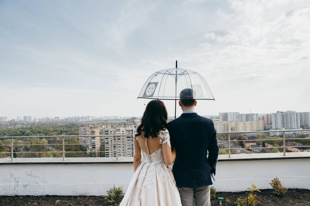 beautiful  young couple of newlyweds with umbrella - Fotó, kép