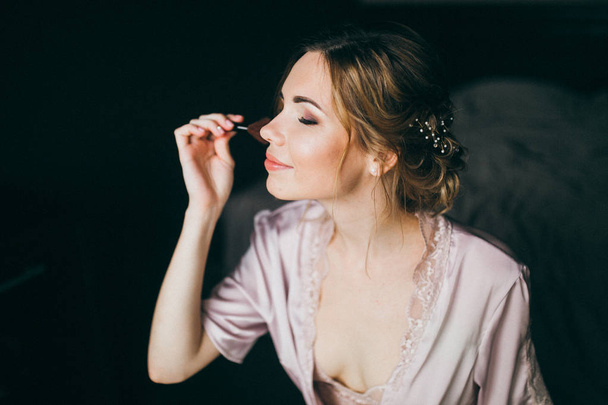 Delicate  young beautiful  bride applying mascara - Foto, imagen