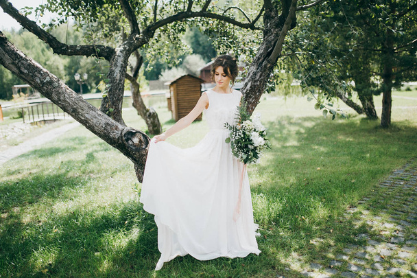 beautiful  young bride posing with flowers - Fotó, kép
