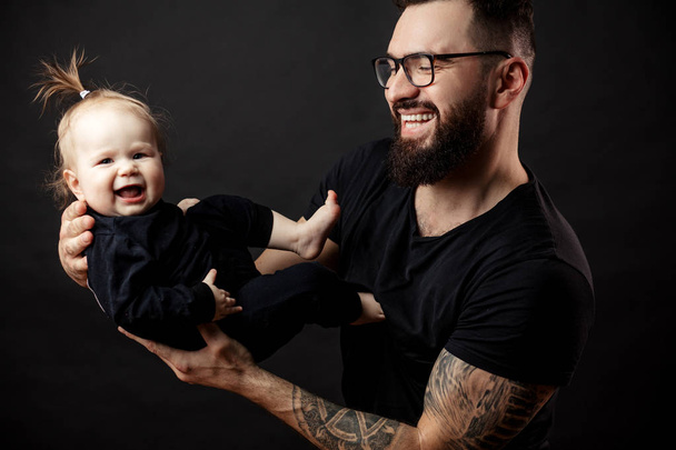 Loving father admires his little baby daughter holding her on hands - Photo, image