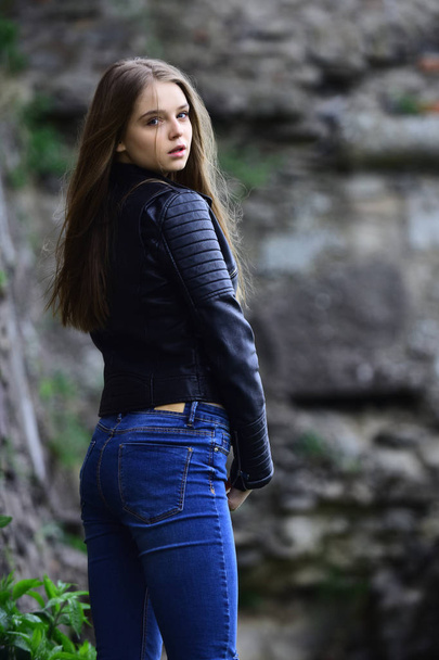 Summer or spring fashion and beauty. girl in casual clothes outdoor. look of girl near stony wall. Sexy woman with long hair at stone. sensual model with makeup after hairdresser. - Fotó, kép
