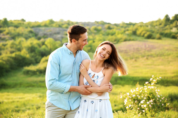 Cute young couple in love posing outdoors on sunny day - Photo, image