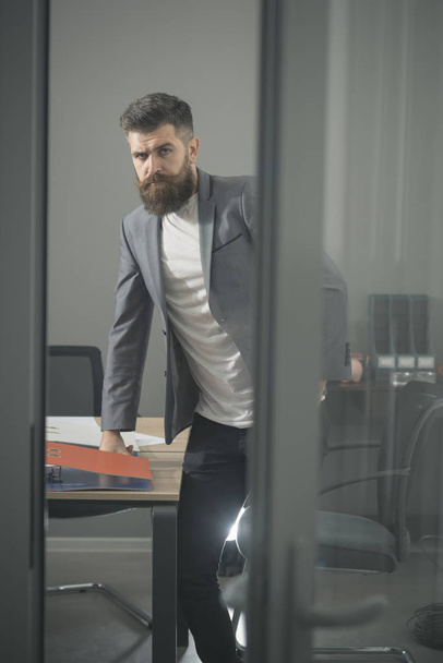 Bearded man look out room door. Businessman in modern office with glass walls. Confident man in casual suit at working place. Business and office lifestyle. Confidence and success concept - Foto, Imagem