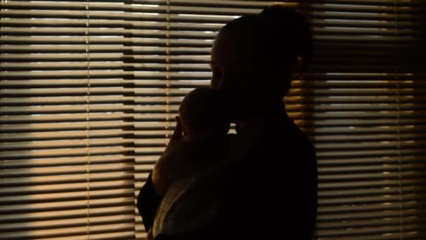 Matka całuje dziecko w oknie - Materiał filmowy, wideo
