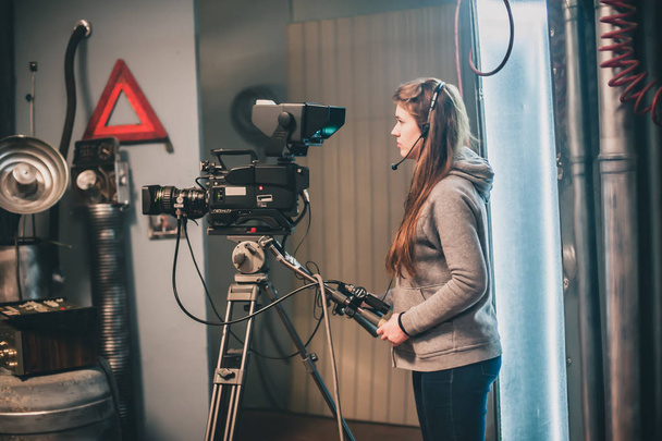 Behind the scene. Female cameraman shooting the film scene with camera in film studio - Zdjęcie, obraz