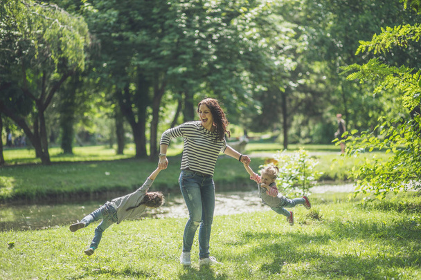 Mutter und Töchter haben Spaß und spielen gemeinsam im öffentlichen Park - Foto, Bild