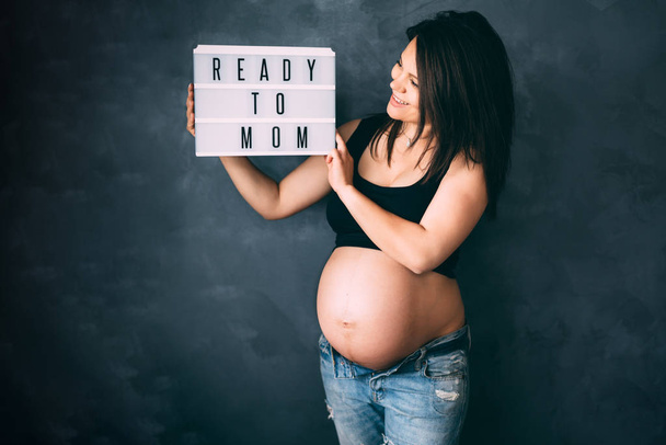 Beautiful pregnant woman enjoying life, smiling and posing for camera with big belly - Photo, image