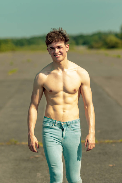 Young adult male walking forward shirtless on a warm summer's day - Fotó, kép