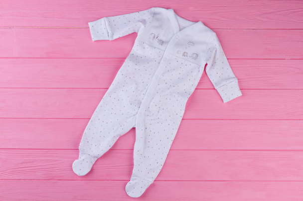 Organik Pamuk tek parça pijama. Üstten görünüm yumuşak bebek uyuyan renkli ahşap zemin üzerinde. Marka Giysi bebekler için. - Fotoğraf, Görsel
