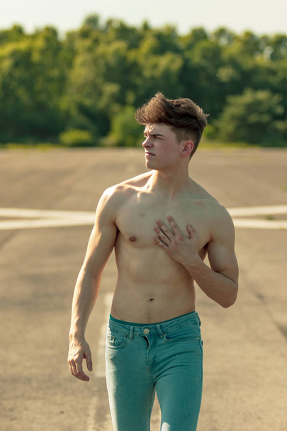 Young adult male walking forward shirtless on a warm summer's day - Foto, imagen