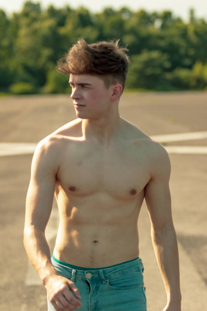Young adult male walking forward shirtless on a warm summer's day - Фото, изображение