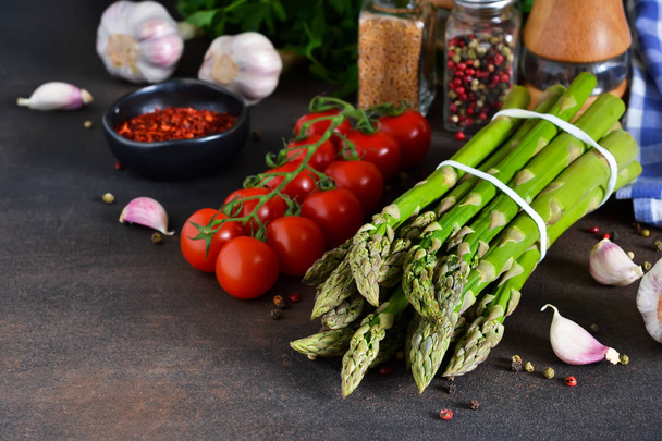 Składniki do gotowania. Świeże warzywa: szparagi, pomidory, czosnek i przyprawy. Żywności ekologicznej. - Zdjęcie, obraz