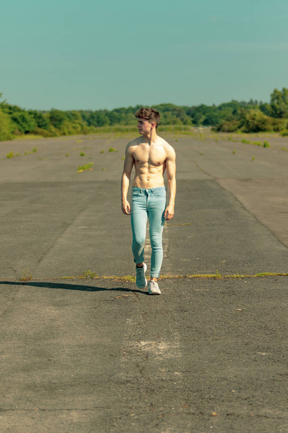 Young adult male walking forward shirtless on a warm summer's day - Foto, Imagem
