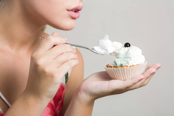 Primo piano colpo di giovane donna bionda mangiare gustoso dolce dessert con crema di burro
 - Foto, immagini