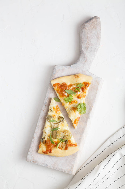 zwei Stücke von weiße Pizza mit Artischocken und Rucola - Foto, Bild