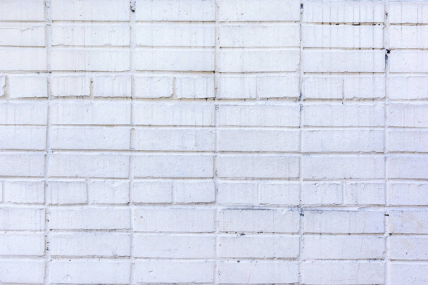 Una pared de pequeños ladrillos pintados con pintura gris-blanca. Textura de mampostería con manchas. Fondo en blanco hermoso
. - Foto, imagen