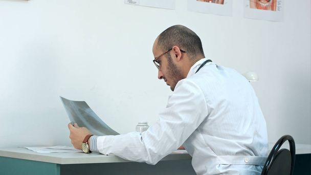 Young male doctor examining chest xray image - Fotografie, Obrázek