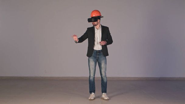 Young male engineer in hardhat with VR glasses designing construction project - Foto, imagen