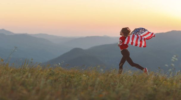 young happy woman with flag of united states enjoying the sunset on natur - Fotografie, Obrázek