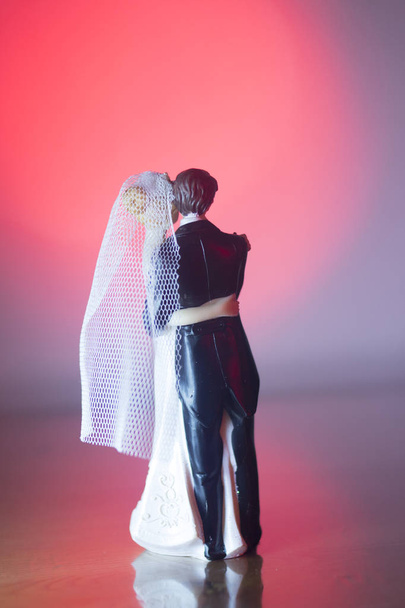 Pareja boda torta superior figuras de plástico con traje de noche de esmoquin, vestido de novia blanco velo. - Foto, Imagen