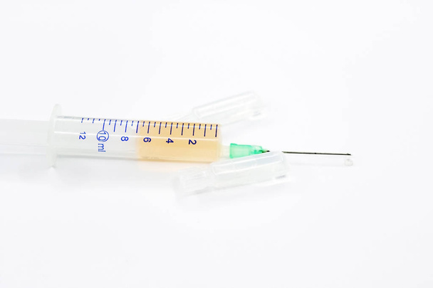 A medical syringe filled with medicine. A syringe with a drug for injection. A syringe with a needle for a prick. Background or texture. Medicines. - Foto, Imagem