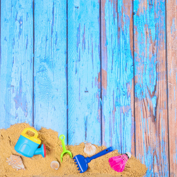 Beach poster on wooden background with sand and plastic toys - Foto, Bild