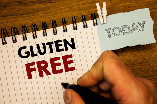 Text sign showing Gluten Free. Conceptual photo Diet with products not containing ingredients like wheatMan creating for today on notebook Hand hold holding pen Wooden background - Photo, Image