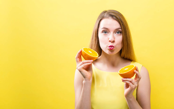 Happy young woman holding oranges - Zdjęcie, obraz
