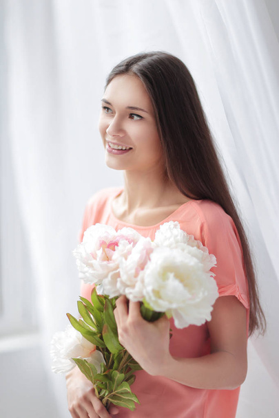 portrait of a young woman with a bouquet of peonies - Foto, Bild