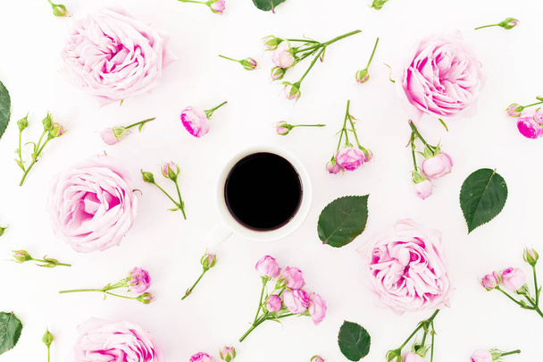 Top view of coffee cup with pink roses on white background. Flat lay - Photo, Image