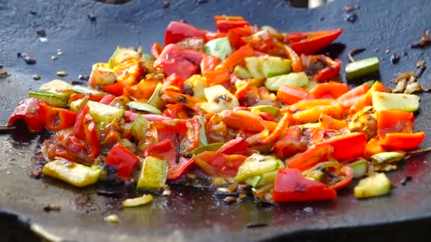 νόστιμα pan ανακατώνει την τηγανισμένη πολύχρωμα φρέσκα λαχανικά στο στάδιο της προετοιμασίας ως μέρος γεύμα υγιείς σύγχρονου τρόπου ζωής σε κοντινό πλάνο - Πλάνα, βίντεο