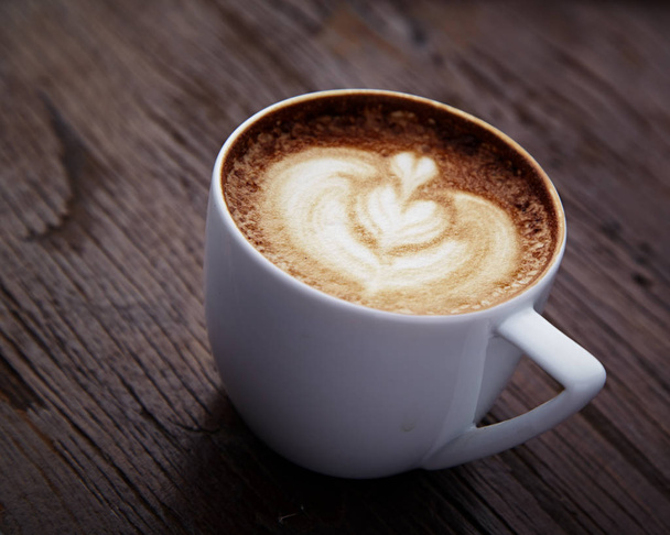 Kalp latte sanat ahşap masa üzerinde fincan  - Fotoğraf, Görsel