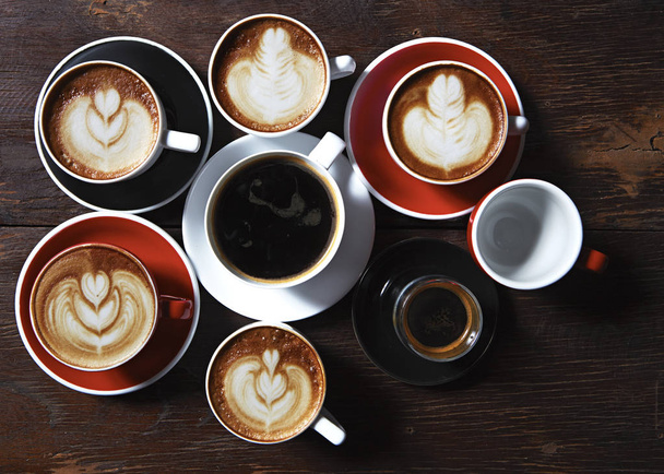 木製の背景、平面図上にコーヒーの多くのカップ。アイデア通信企業コンセプト - 写真・画像